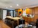 Well-equipped kitchen featuring stainless steel appliances, wood cabinets, a granite countertop island, and a formal dining area at 106 Palo Verde Dr, Leesburg, FL 34748