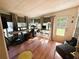 Bright sunroom with hardwood floors, natural light, and an open door to the backyard at 106 Palo Verde Dr, Leesburg, FL 34748