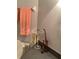 Small bathroom corner with grey floors and orange towels hanging on the wall at 1104 Illinois Ave, St Cloud, FL 34769