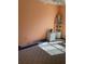 Carpeted bedroom with blinds, wicker shelving, and light-orange walls at 1104 Illinois Ave, St Cloud, FL 34769