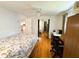 Bedroom with light colored walls, wood-look floors, ceiling fan, desk, and mirrored closet doors at 121 Bougainvillea Dr, Leesburg, FL 34748