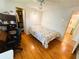 Bedroom features wood-look floors, walk in closet and adjacent bathroom at 121 Bougainvillea Dr, Leesburg, FL 34748