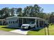 Inviting single-story home showcasing a carport, lush green lawn, and a well-kept exterior at 121 Bougainvillea Dr, Leesburg, FL 34748