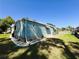 View of the home with blue siding, a well-manicured lawn, and mature trees at 121 Bougainvillea Dr, Leesburg, FL 34748