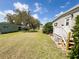 Lush backyard featuring a well-manicured lawn and side porch, ideal for relaxing outdoor living at 139 Royal Palm Dr, Leesburg, FL 34748