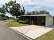 Single-story home featuring a screened porch, carport, and well-maintained landscaping at 139 Royal Palm Dr, Leesburg, FL 34748