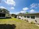 Backyard view showcasing a lush lawn with well-maintained landscaping and exterior features at 139 Royal Palm Dr, Leesburg, FL 34748