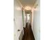 Hallway with dark wood flooring and white walls with decorative light fixture at 139 Royal Palm Dr, Leesburg, FL 34748
