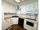 Well-lit kitchen featuring white appliances, updated cabinets, and a black sink at 139 Royal Palm Dr, Leesburg, FL 34748