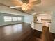 View of living room and kitchen featuring hardwood floors and white kitchen cabinets at 139 Royal Palm Dr, Leesburg, FL 34748