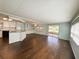 View of living room and kitchen featuring hardwood floors, island, and sliding glass doors at 139 Royal Palm Dr, Leesburg, FL 34748