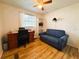 Bedroom area with wood laminate floor, work desk, and comfortable sofa at 141 Aspen Cir, Leesburg, FL 34748