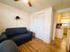 Cozy bedroom with wood laminate floors, closet, and view of attached kitchen at 141 Aspen Cir, Leesburg, FL 34748