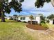 Charming home featuring a well-maintained lawn and landscaped garden beds for enhanced curb appeal at 141 Aspen Cir, Leesburg, FL 34748