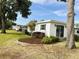 Charming single-story home featuring well-maintained landscaping, mature trees, and a welcoming exterior at 141 Aspen Cir, Leesburg, FL 34748