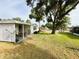 Expansive lawn showcasing a well-maintained home and covered patio area, perfect for outdoor enjoyment at 141 Aspen Cir, Leesburg, FL 34748