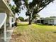 Side yard view displaying a grassy lawn and a home with an inviting covered patio, ideal for relaxation at 141 Aspen Cir, Leesburg, FL 34748