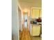 Hallway with wood-look floors, yellow kitchen cabinets, and neutral walls at 141 Aspen Cir, Leesburg, FL 34748