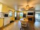 Eat-in kitchen featuring yellow cabinets, laminate countertops, stainless steel refrigerator, and wood-look floors at 141 Aspen Cir, Leesburg, FL 34748