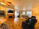 Inviting living room boasts a decorative fireplace, wood-look floors, and sunroom access at 141 Aspen Cir, Leesburg, FL 34748