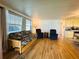 Cozy living room showcases a futon, wood-look floors, and plenty of natural light at 141 Aspen Cir, Leesburg, FL 34748