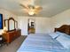 Inviting bedroom with a classic dresser, ceiling fan, and comfortable bed at 141 Aspen Cir, Leesburg, FL 34748