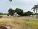 Street view with sidewalks and landscaping leading to commercial building with greenery and mature trees at 141 Aspen Cir, Leesburg, FL 34748