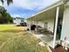 Covered patio with a dining table, chairs, and outdoor grill, perfect for relaxing and entertaining guests at 141 Aspen Cir, Leesburg, FL 34748