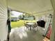 Covered patio with a dining table, chairs, and outdoor grill, perfect for relaxing and entertaining guests at 141 Aspen Cir, Leesburg, FL 34748
