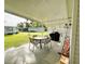 Covered patio with a dining table, chairs, and outdoor grill, perfect for relaxing and entertaining guests at 141 Aspen Cir, Leesburg, FL 34748