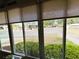 Enclosed sunroom offering neighborhood views through large windows with window coverings at 141 Aspen Cir, Leesburg, FL 34748