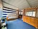 Cozy sunroom with blue carpet, futon, dresser, and striped curtains at 141 Aspen Cir, Leesburg, FL 34748