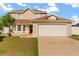 Two-story home featuring an attached garage, well-manicured lawn, and a classic architectural design at 144 Pinewood Cir, Kissimmee, FL 34743