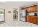 Kitchen with stainless steel refrigerator, dark wood cabinets, granite countertops, and a view into the dining room at 144 Pinewood Cir, Kissimmee, FL 34743