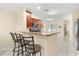 Well-lit kitchen featuring a granite breakfast bar with seating, tile flooring, and modern appliances at 144 Pinewood Cir, Kissimmee, FL 34743