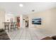 Open living area featuring tile floors, a breakfast bar, and a wall-mounted television at 144 Pinewood Cir, Kissimmee, FL 34743
