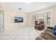 Bright living room features tile floors, a large window, and a comfortable seating area with a TV at 144 Pinewood Cir, Kissimmee, FL 34743