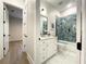 Well-lit bathroom featuring stylish vanity with gray tiled shower and view of bedroom, offering a serene retreat at 15373 Evans Ranch Rd, Lakeland, FL 33809