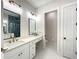 Bright bathroom with dual sinks, quartz counters, stylish lighting and elegant gray tiled shower, exuding modern charm at 15373 Evans Ranch Rd, Lakeland, FL 33809