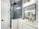 Modern bathroom featuring blue tile shower, double vanity with quartz countertop, and sleek black framed mirror at 15373 Evans Ranch Rd, Lakeland, FL 33809