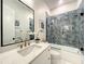 Modern bathroom features a tiled shower, white vanity with quartz counters, and black framed mirror at 15373 Evans Ranch Rd, Lakeland, FL 33809