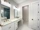 Dual sink bathroom with tiled shower, quartz counters, and modern lighting at 15373 Evans Ranch Rd, Lakeland, FL 33809