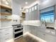 Beautiful white kitchen featuring open shelving, modern appliances, and stylish backsplash at 15373 Evans Ranch Rd, Lakeland, FL 33809