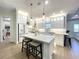 Bright, open kitchen features white cabinets, a large island, pendant lighting and stainless steel appliances at 15373 Evans Ranch Rd, Lakeland, FL 33809