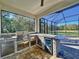 Outdoor kitchen with stainless steel grill, granite counters, and beverage center in screened lanai at 15373 Evans Ranch Rd, Lakeland, FL 33809