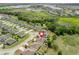 Aerial view of home and surrounding community featuring mature trees and nearby lake at 1936 Bell Creek Loop, Fruitland Park, FL 34731