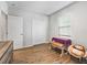 Neutral bedroom with wood-look floors, a window, a stylish chair, and a modern dresser at 1936 Bell Creek Loop, Fruitland Park, FL 34731
