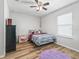 Bright bedroom with wood-look floors, a ceiling fan, and a window with natural light at 1936 Bell Creek Loop, Fruitland Park, FL 34731