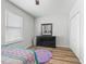 Bedroom featuring wood-look flooring, natural light, dresser, and a cozy purple rug at 1936 Bell Creek Loop, Fruitland Park, FL 34731