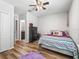 Bedroom with wood-look floors and an ensuite bathroom, decorated with a cozy, colorful bed at 1936 Bell Creek Loop, Fruitland Park, FL 34731